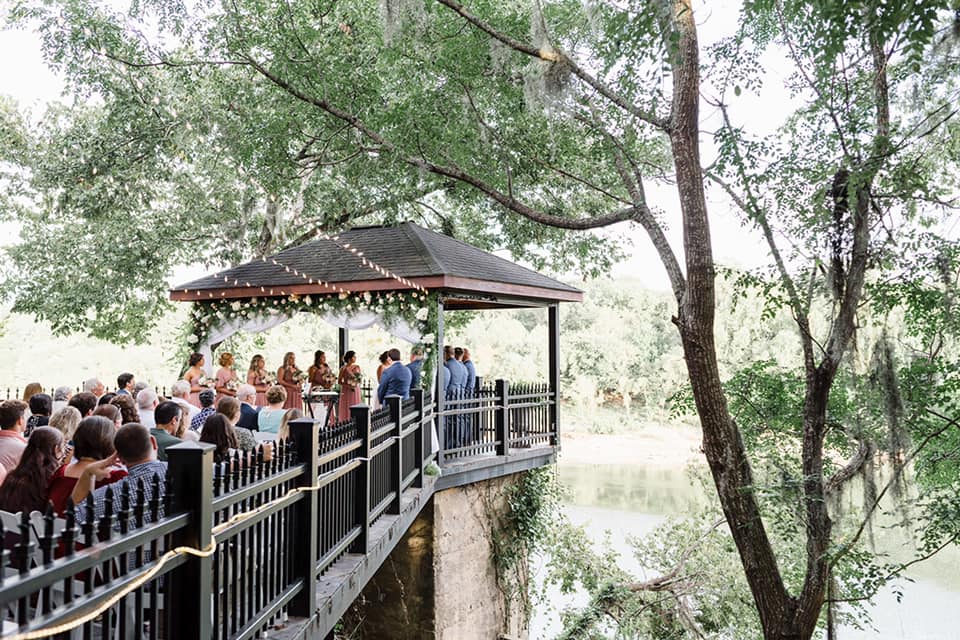 A group of people standing on top of a wooden bridge.